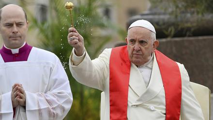 Papst Franziskus (r) segnet die Gläubigen mit Oliven- und Palmzweigen, bevor er die Palmsonntagsmesse auf dem Petersplatz im Vatikan zelebriert, einen Tag nachdem er aus dem Krankenhaus in Rom entlassen wurde, wo er wegen einer Bronchitis behandelt wurde.
