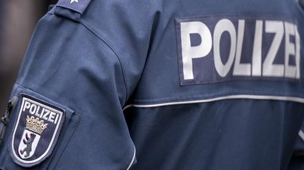 Die Aufschrift Polizei und der Wappen von Berlin auf der Uniform eines Polizeibeamten