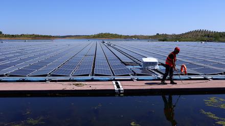 Ein Arbeiter ist bei der Installation des größten schwimmenden Solarparks von EDP (Energias de Portugal) auf einem Staudamm in Europa zu sehen.