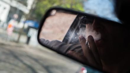 Eine Person raucht im Auto (Symbolbild). 
