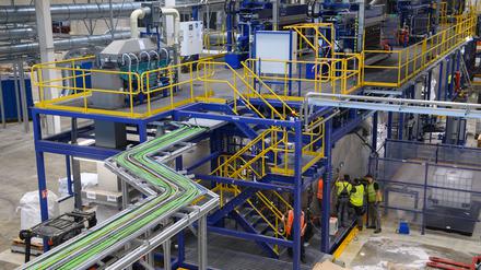 Mitarbeiter der Firma «Li-Cycle» arbeiten an einer Maschine mit der Batterien in ihre Bestandteile zerlegt werden. Das kanadische Unternehmen «Li-Cycle» hat bei Magdeburg nach eigenen Angaben eine der größten Recyclinganlagen für Lithium-Ionen-Batterien in Europa eröffnet. 