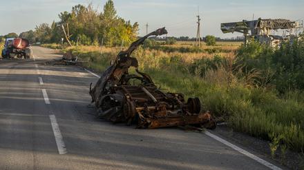 Zerstörte Fahrzeuge stehen auf einer Straße in der Region Charkiw.