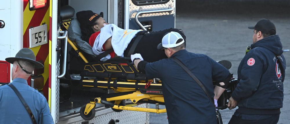 Sanitäter laden eine Frau nach einer Schießerei bei der Super Bowl LVIII-Siegparade der Kansas City Chiefs in einen Krankenwagen.