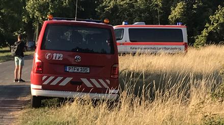 Zwei Rettungsfahrzeuge parken im Park Babelsberg auf einer Wiese.