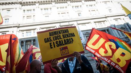 „Die Preise für Gas, Licht, Benzin steigen. Und die Gehälter?“ steht auf dem Plakat eines Demonstranten am Montag in Rom.