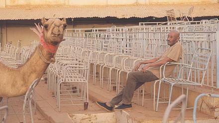Blick nach vorn. Ibrahim Shaddad mit Kamel im leeren Kino. 
