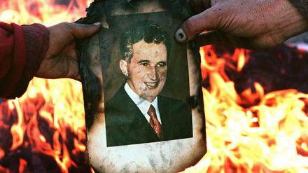 Demonstranten verbrennt das Foto des rumänischen Dikators Nicolae Ceaușescu. Am 25.12.1989 wurde er hingerichtet.