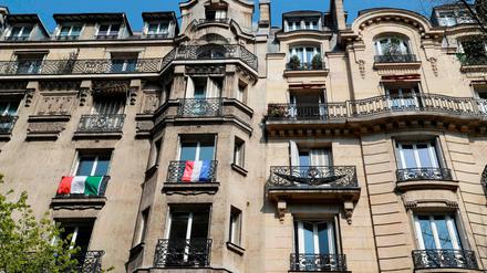 EU in Quarantäne. Die italienische und die französische Flagge an einer Häuserfront in Paris