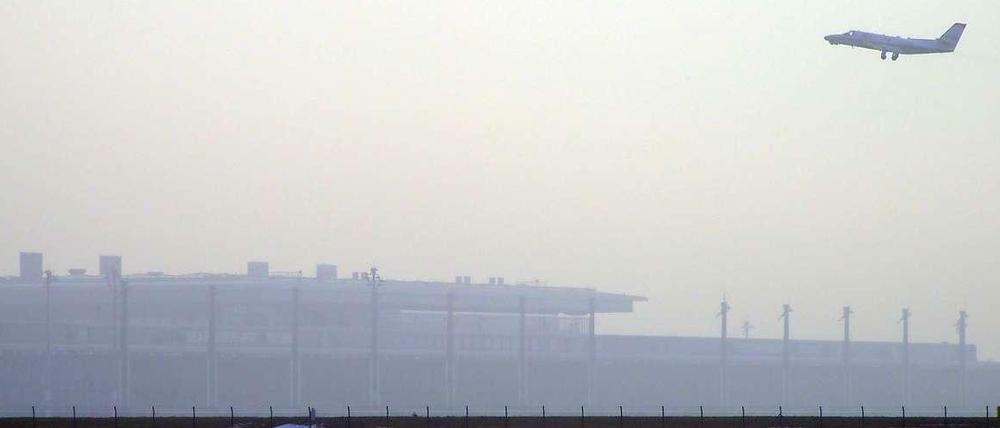 Ein Flugzeug über dem neuen Flughafen BER. 