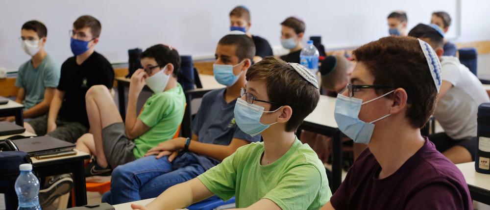 Israel, Modi'in: Schüler mit Mundschutzen sitzen in einem Klassenzimmer. 