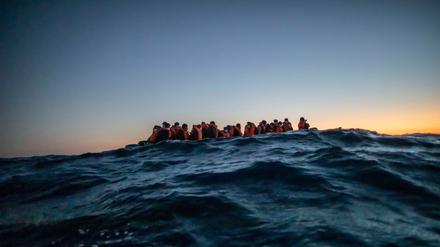 Migranten aus afrikanischen Nationen warten in einem Boot auf Helfer, 122 Meilen vor der libyschen Küste im Mittelmeer.