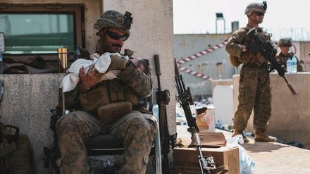 Ein U.S.-Marine versorgt ein gerettetes Baby.