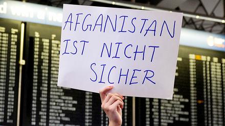 Eine Demonstrantin protestiert am Flughafen in Frankfurt am Main gegen Abschiebungen nach Afghanistan. 