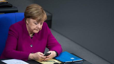 Bundeskanzlerin Angela Merkel mit ihrem Smartphone im Bundestag 