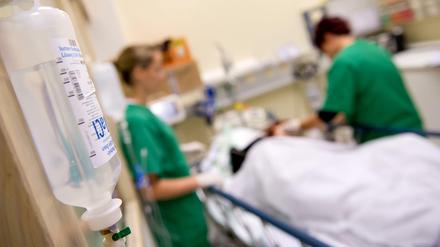 Medizinisches Personal versorgt in einem Krankenhaus einen Patienten.