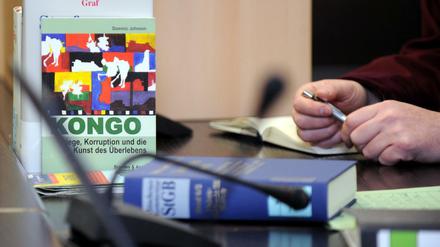 In einem Gerichtssaal im Oberlandesgericht liegt neben Prozessunterlagen und einem Gesetzbuch ein Buch über Kriminalität im Kongo. 