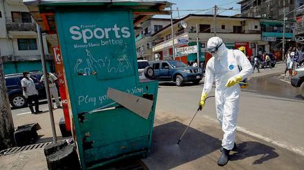 Ein liberianischer Helfer desinfiziert eine Straßenecke, an der ein mit Ebola Infizierter aufgegriffen wurde. 