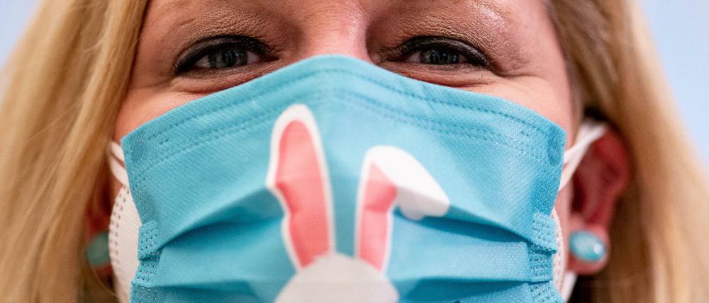 Eine Frau trägt im schleswig-holsteinischen Landtag einen Mund-Nasen-Schutz mit einem aufgedruckten Osterhasen.
