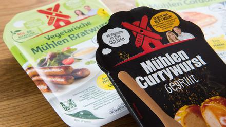 Die "Mühlen Currywurst - gegrillt" vom Hersteller Rügenwalder Mühle liegt mit vegetarischen und veganen Produkten auf einem Tisch. 