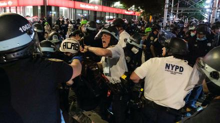 Ein Beamter der New Yorker Polizei schlägt mit einem Knüppel nach einem Demonstranten.