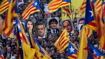 Demonstranten mit Fahnen und Bilder der ehemaligen katalanischen Regierungsmitglieder
