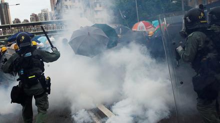 Polizisten und Demonstranten in Wolken von Tränengas in Hongkong 