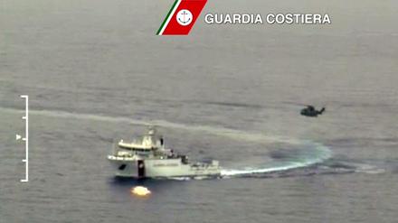 Nach der erneuten Flüchtlingskatastrophe: Ein Boot und ein Hubschrauber der italienischen Küstenwache im Rettungseinsatz auf dem Mittelmeer.