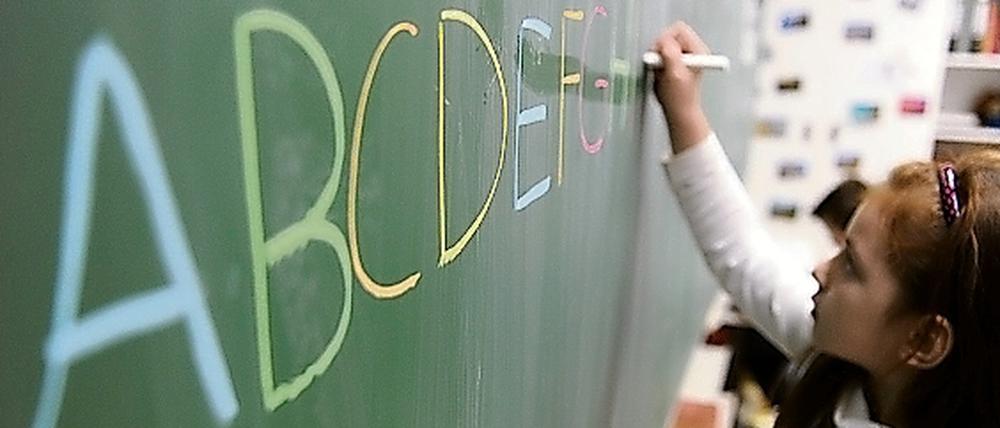 Eine Schülerin schreibt in einer Schule in Hamburg das ABC an die Tafel. 