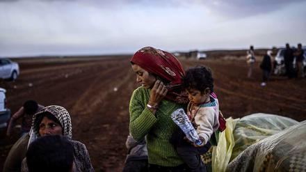 Syrische Kurden warten an der Grenze zur Türkei nahe der Stadt Suruc darauf, die Grenze überschreiten zu dürfen. Sie sind vor Kämpfen und dem Islamischen Staat geflohen. Hunderttausende Menschen sind auf der Flucht vor den selbst ernannten Gotteskriegern. 