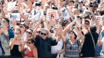 Nach einer Schweigeminute im Gedenken an die Opfer des Terrors vom Vortag applaudieren die Menschen auf der Placa de Catalunya in Barcelona.