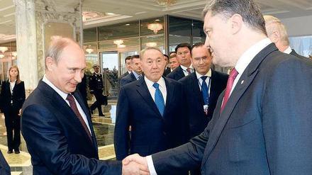 Unter Zeugen. Zur Begrüßung gaben sich Russlands Präsident Putin und sein ukrainischer Kollege Poroschenko die Hand.