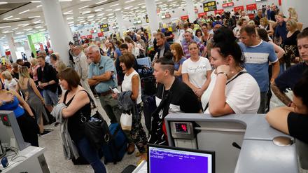 Passagiere stehen am Tag der Insolvenz des britischen Reisekonzerns Thomas Cook im Flughafen Palma de Mallorca und warten an den Check-In-Schaltern. 