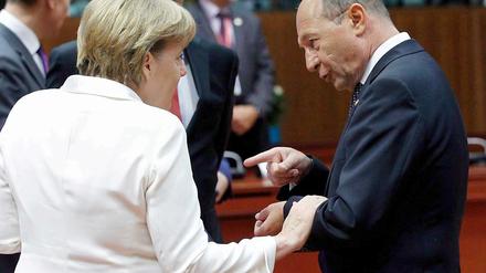 Bundeskanzlerin Merkel und der rumänische Präsident Basescu reden angeregt auf dem EU-Gipfel miteinander.