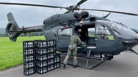 Ein Soldat entlädt am Nürburgring Kisten mit Trinkwasser aus einem Hubschrauber der Spezialkräfte vom Typ H145M. 