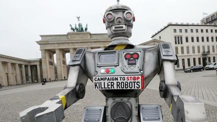 Eine Roboterfigur steht vor dem Brandenburger Tor. Der Nachbau ist Teil einer internationalen Kampagne der NGO "Facing Finance" zum Verbot von Killer-Robotern.