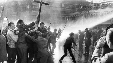 Demonstranten mit Kreuzen im Strahl der Wasserwerfer. Der 14. April 1968 auf dem Kurfürstendamm.