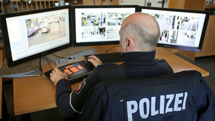 Ein Polizist überwacht in Duisburg an Monitoren die übertragenen Bilder von Videokameras.