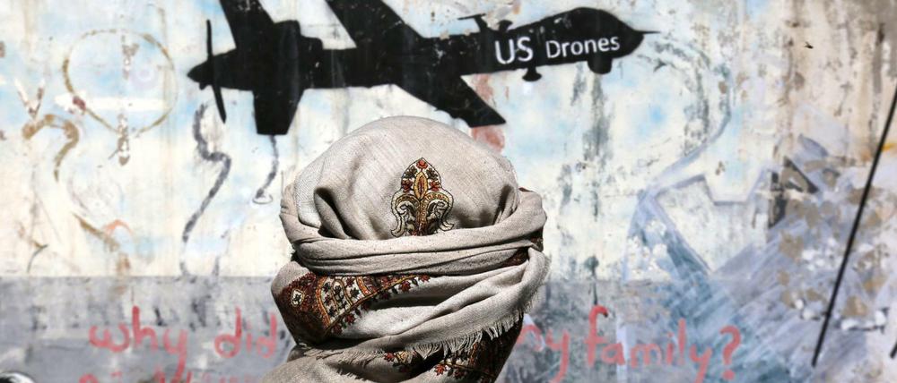 Ein Jemenit steht vor einem Graffiti, mit dem gegen US-Drohnenoperationen protestiert wird. 