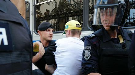 Polizeibeamte verhaften einen Mann vor einer Kundgebung in Moskau. 