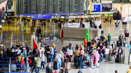 Reisende stehen in der Abflughalle im Terminal 1 am Flughafen in Frankfurt.