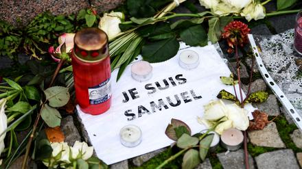 Vor der französischen Botschaft liegen Blumen, Kerzen und ein Blatt mit der Aufschrift ·Je suis Samuel·. In einem Pariser Vorort wurde der Lehrer Samuel Paty auf der Straße von einem mutmaßlichen Islamisten ermordet. 