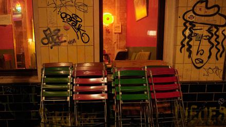 Zusammengeklappte Stühle vor einer Berliner Kneipe.