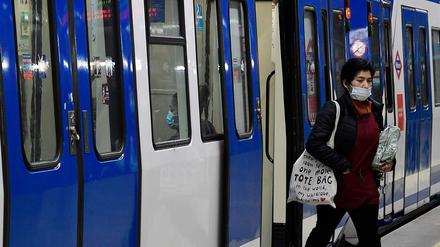Eine Frau mit Maske steigt an der Atocha Station in Madrid aus dem Zug. Das Land fährt schrittweise seine Wirtschaft wieder hoch.