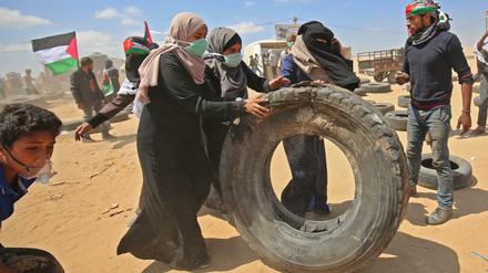 Palästinenserinnen sammeln Lkw-Reifen, die in Brand gesteckt werden sollen. Der Rauch soll den israelischen Soldaten die Sicht nehmen.