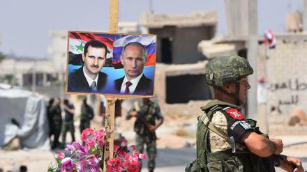 Verbündete: Foto von Syriens Diktator Assad und dem russischen Präsidenten an einem Posten in Syrien 