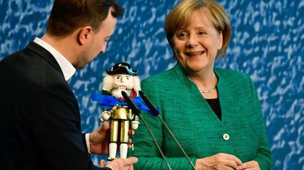 Ein Nussknacker für die Kanzlerin: JU-Chef Paul Ziemiak überreicht Angela Merkel ein Präsent für die bevorstehenden Verhandlungen.
