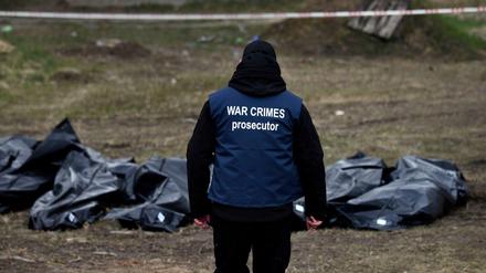 Ein Ermittler in Butscha trägt eine Weste mit der Aufschrift „War Crimes Prosecutor“ („Ankläger für Kriegsverbrechen“).