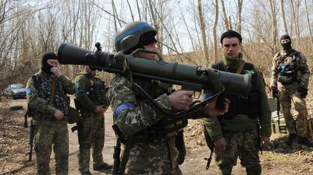 Ukrainische Soldaten nahe Charkiw studieren ein schwedisches schultergestütztes Waffensystem während einer Übung.