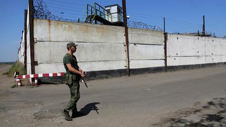Ein Soldat steht Wache neben der Mauer eines Gefängnisses in Oleniwka, in einem von Russland kontrollierten Gebiet. Russland und die Ukraine beschuldigten sich am gegenseitig, ein Gefängnis in einer separatistischen Region der Ostukraine beschossen zu haben. 
