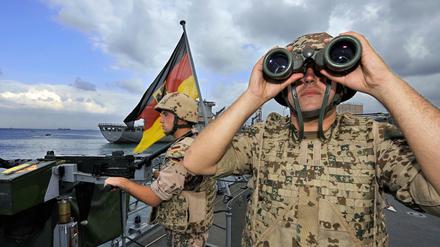 Deutsche Marine-Soldaten halten an Bord der Fregatte „Karlsruhe“ an einem Maschinengewehr Wache. 